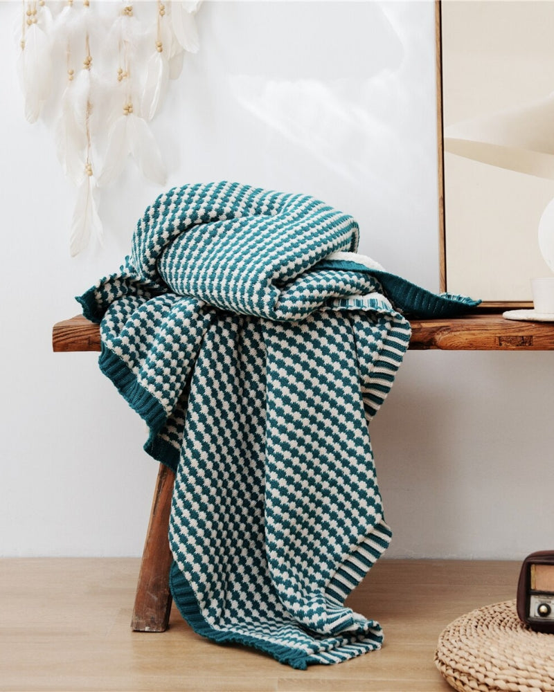 Plaid vert à carreaux plié sur un lit