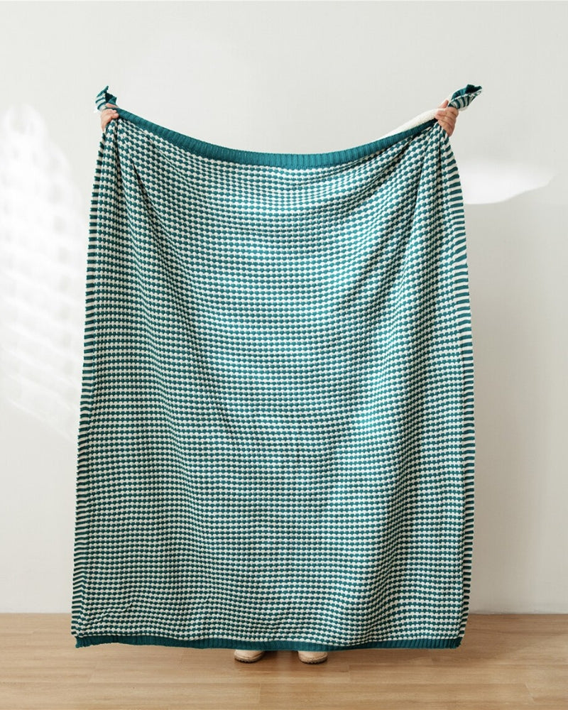 Plaid vert à carreaux drapé sur un fauteuil