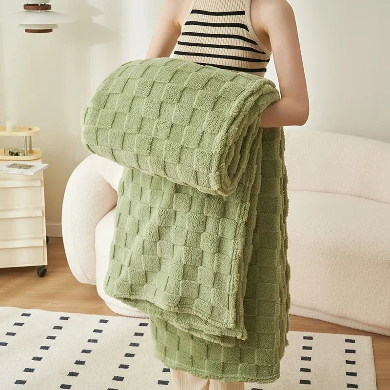 Plaid vert à carreaux en Pilou Pilou sur un canapé