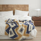 Plaid polaire avec motifs croisés sur canapé beige