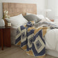 Plaid polaire bleu, camel et crème sur fauteuil