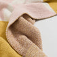Plaid bohème drapé sur un fauteuil, motifs marron visibles