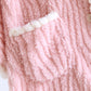 Vue de face du poncho rose avec poches blanches