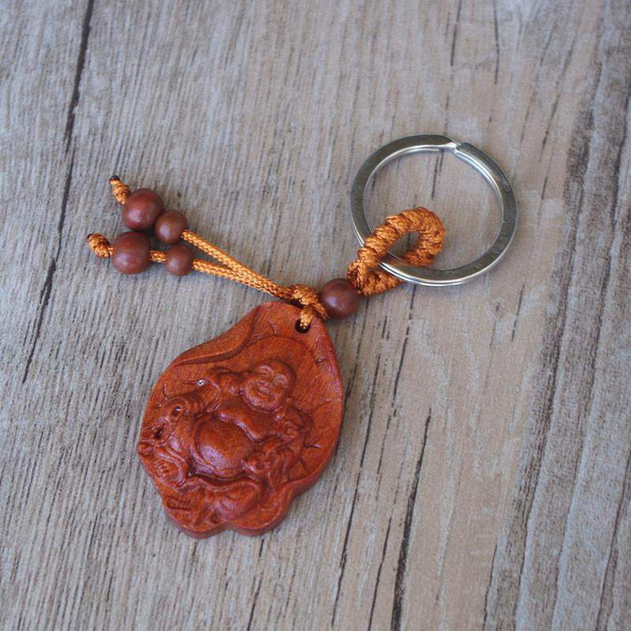 Porte-clés Bouddha rieur en bois sur feuille de lotus