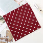 Foulard rouge à pois posé sur une surface blanche
