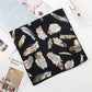 Gros plan sur les motifs plumes du foulard noir