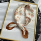 Foulard brun enroulé, montrant sa texture lisse