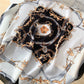 Détail du tissu lisse avec motifs orange et argentés