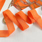 Foulard orange drapé sur une surface, lumière naturelle