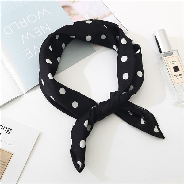 Gros plan sur le tissu noir à pois du foulard