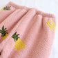 Détail des motifs d'ananas sur le tissu rose du pyjama