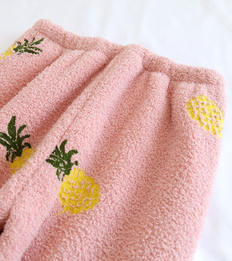 Détail des motifs d'ananas sur le tissu rose du pyjama