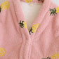 Motifs d'ananas sur fond rose, détail du bas du pyjama