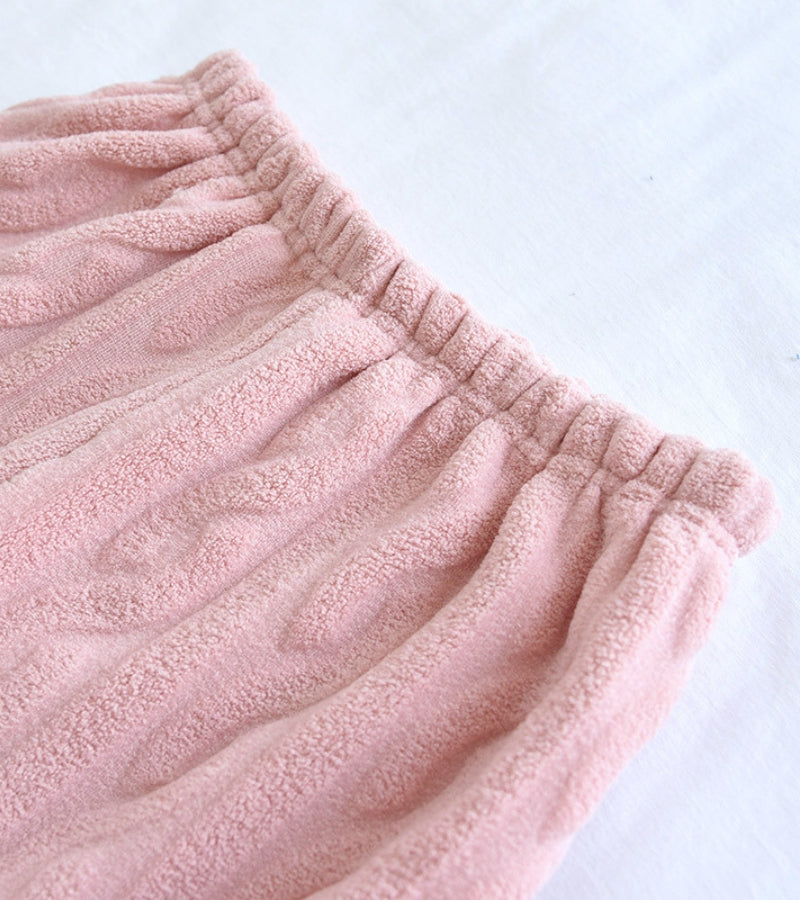 Détail du col V élégant du pyjama rose en velours