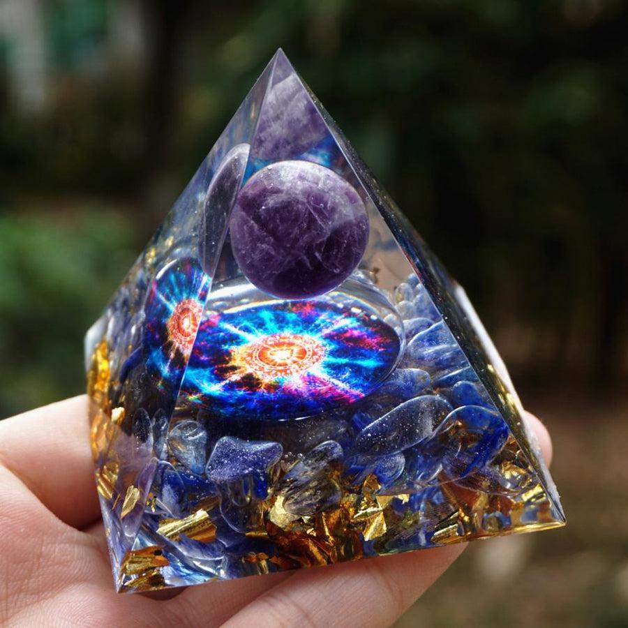 Pyramide orgonite sur fond blanc, mettant en valeur les pierres