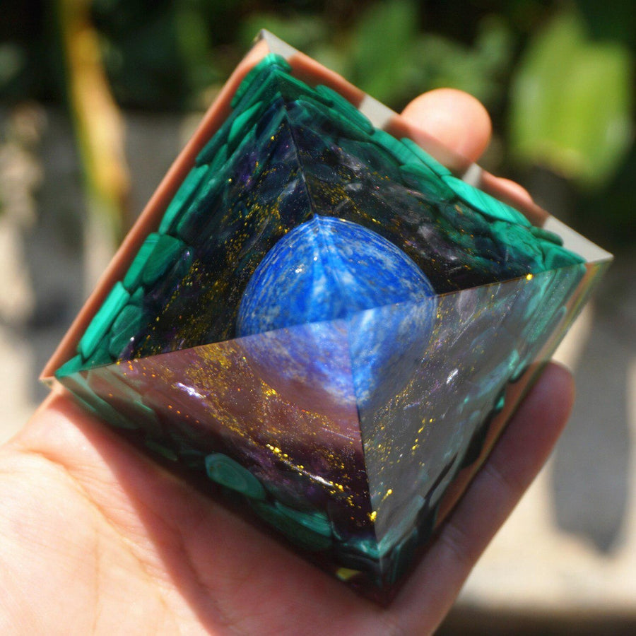 Pyramide Orgonite sur fond blanc, mettant en valeur la Malachite