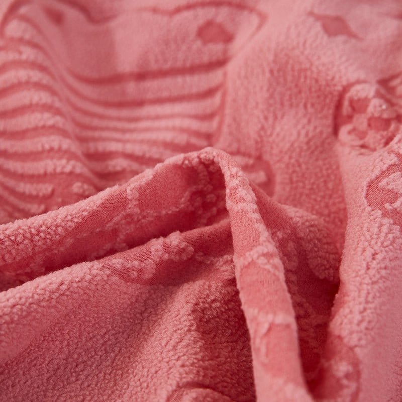 Housse polaire rose sur coussin, motif ours visible