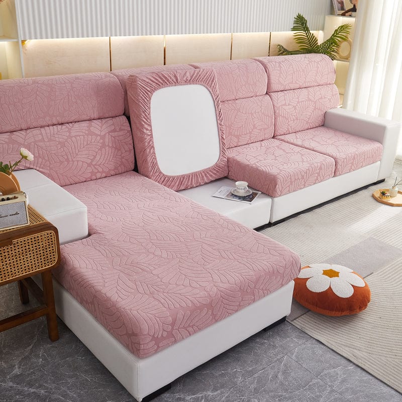 Housse polaire rose installée sur un canapé, motif palmier visible