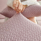 Housse polaire rose pâle sur coussin de canapé