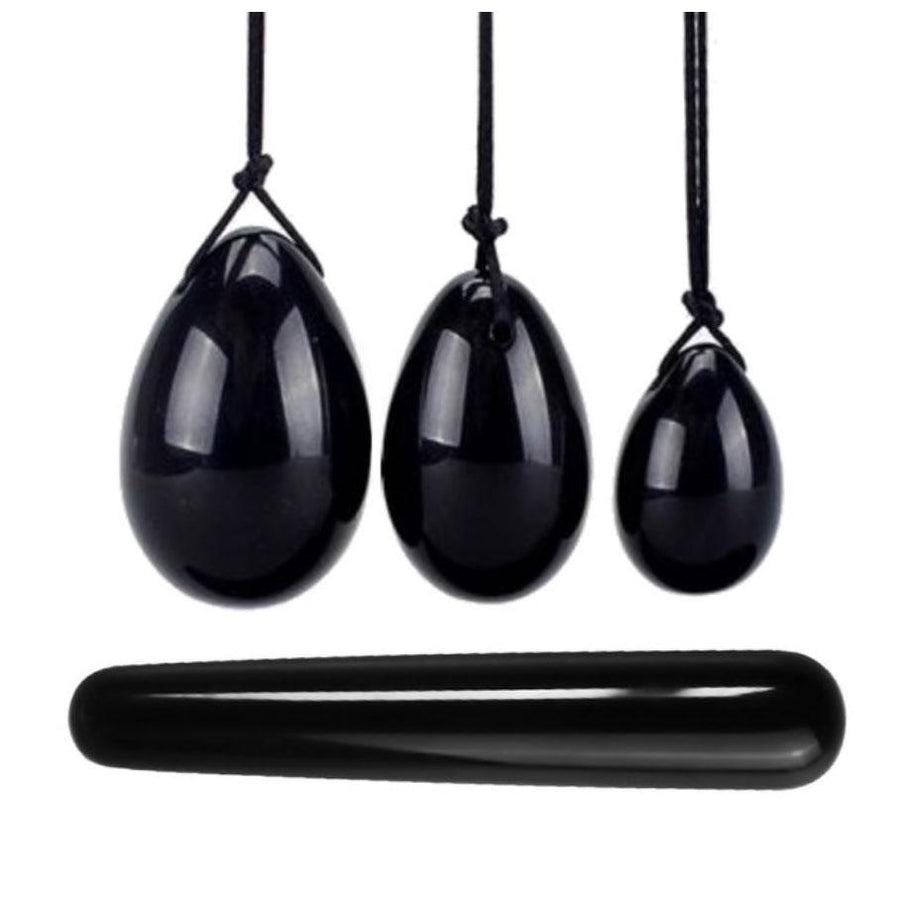Trois œufs de Yoni en obsidienne sur fond blanc