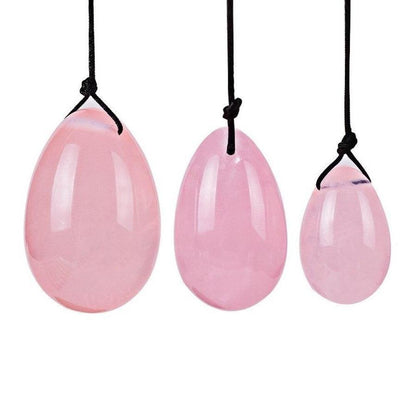 Ensemble complet d'œufs de Yoni en quartz rose sur tissu clair