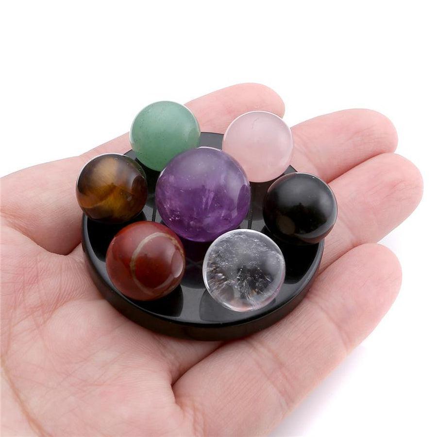 Sphères de chakra colorées posées sur une base noire lisse