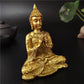 Statue Bouddha or en position namasté sur fond neutre