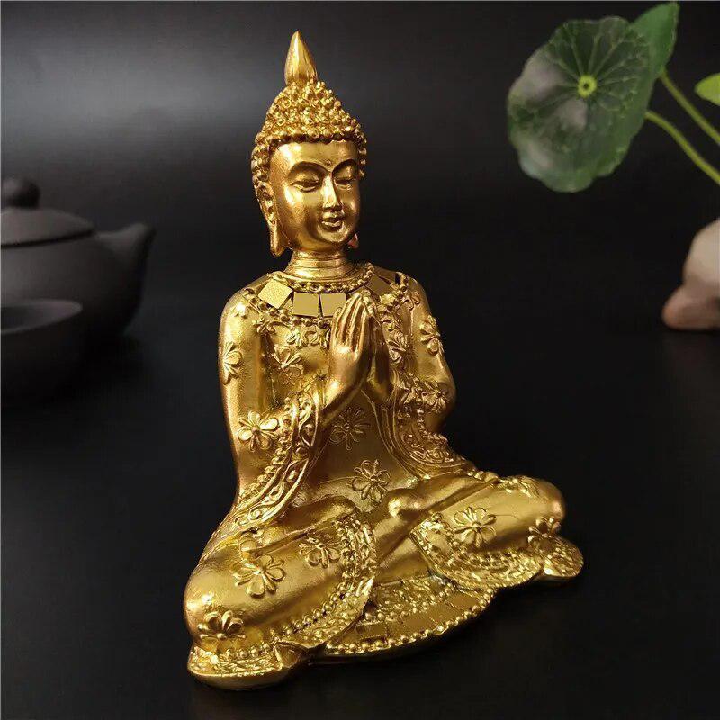 Statue Bouddha or en position namasté sur fond neutre