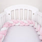 Tour de lit tressé rose et blanc sur lit bébé