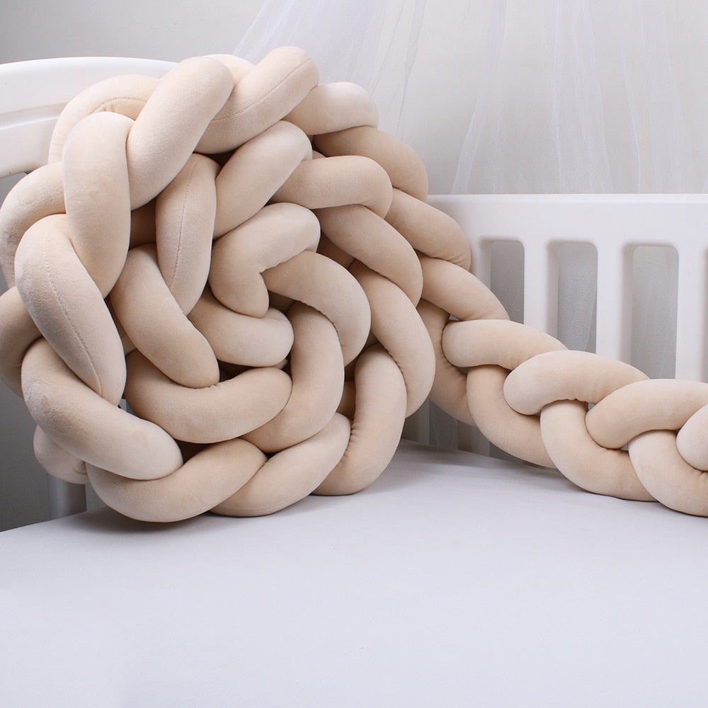 Tresse de lit beige en coton doux sur un lit bébé