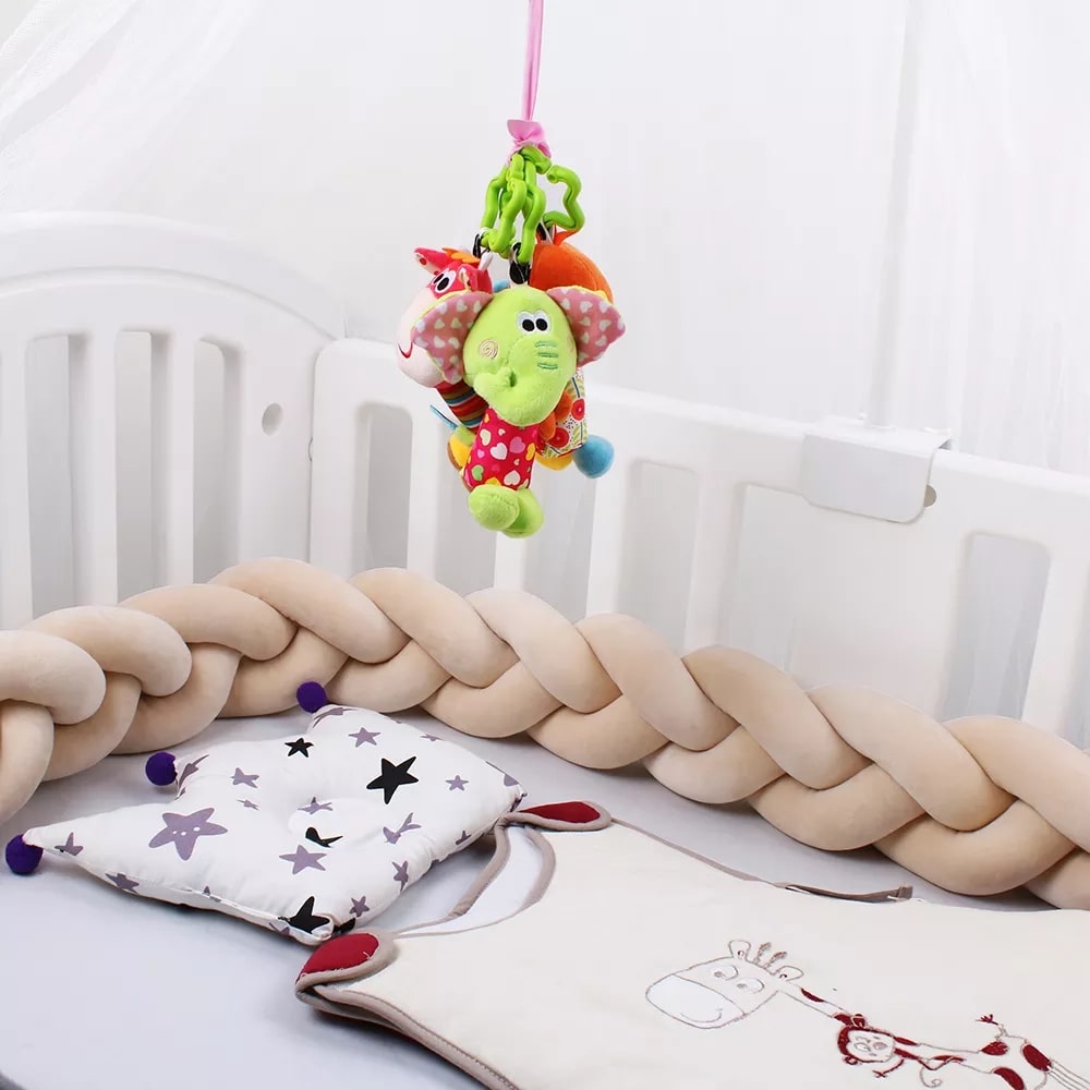Tresse de lit beige entourant un berceau en bois
