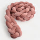 Tresse de lit terracotta en velours sur un lit bébé