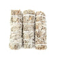 Trio de bâtons de sauge blanche posés sur une surface en bois