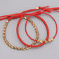 Vue détaillée des perles de cuivre sur bracelet rouge