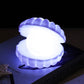 Veilleuse coquillage LED posée sur une table, ambiance apaisante