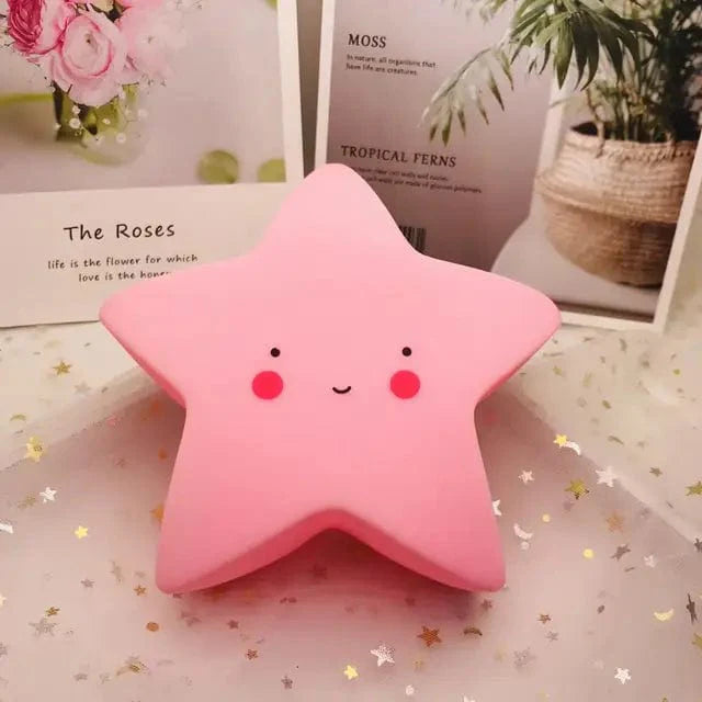 Veilleuse étoile rose LED sur table en bois