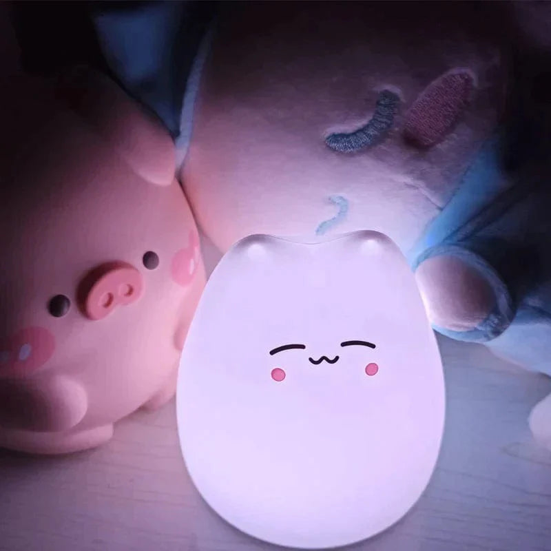 Veilleuse chat LED sur une table de chevet