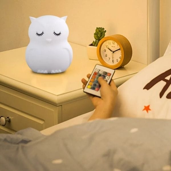 Veilleuse hibou en silicone allumée sur une table