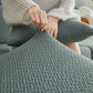 Housse polaire verte sur coussin, motif laine visible
