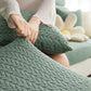 Housse polaire verte sur coussin de canapé, motif laine