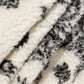Détail des motifs ethniques sur une veste en peluche crème