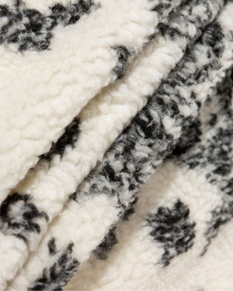 Détail des motifs ethniques sur une veste en peluche crème