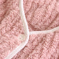 Veste de pyjama rose posée sur un lit