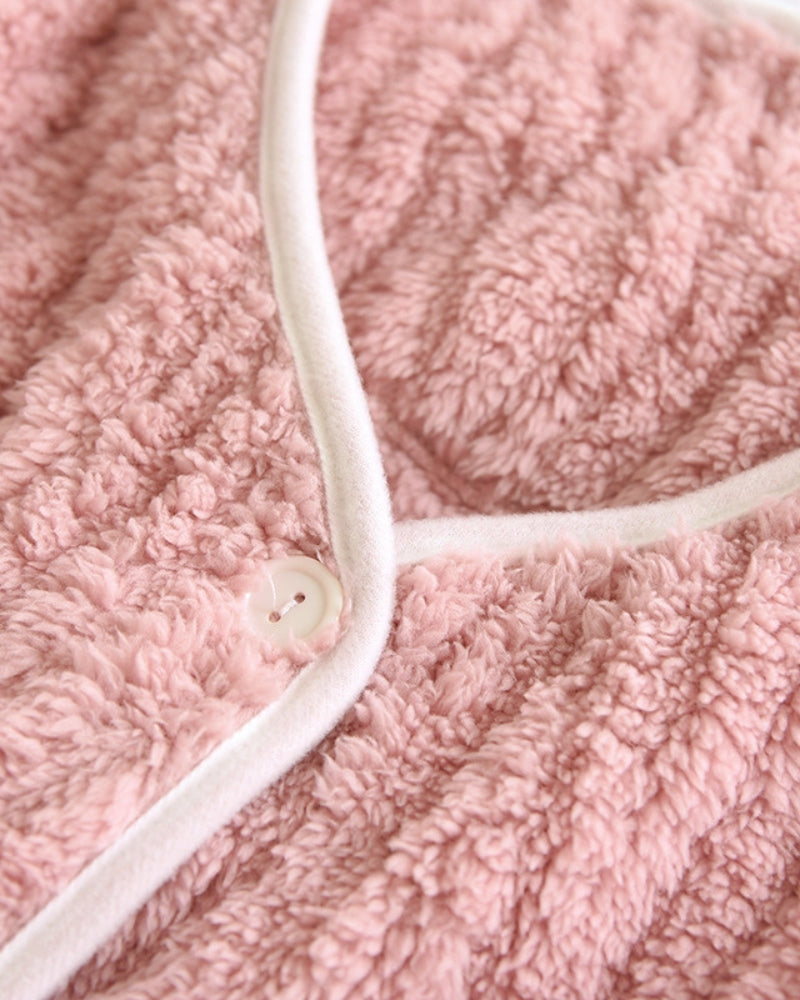 Veste de pyjama rose posée sur un lit